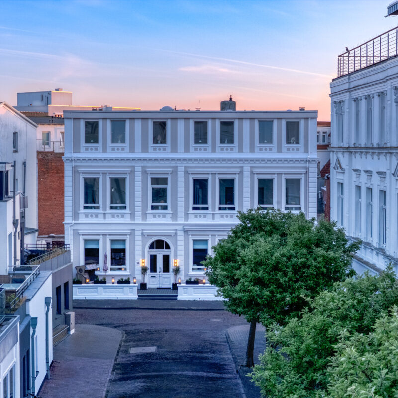 Abbildung eines Hotels mit Gastronomie auf Norderney mit hochwertiger historischer Fassade.